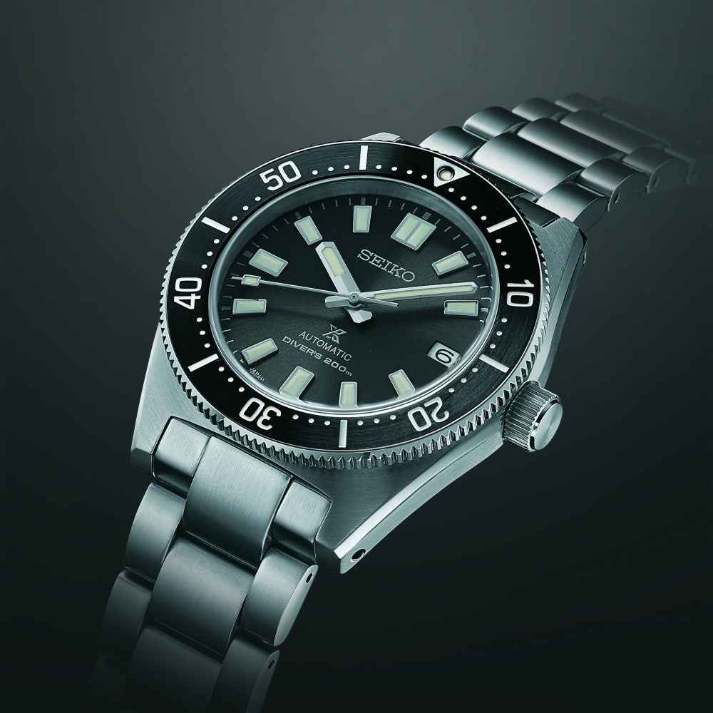 Orologio subacqueo acciaio con quadrante nero, lunetta graduata e bracciale a maglie.