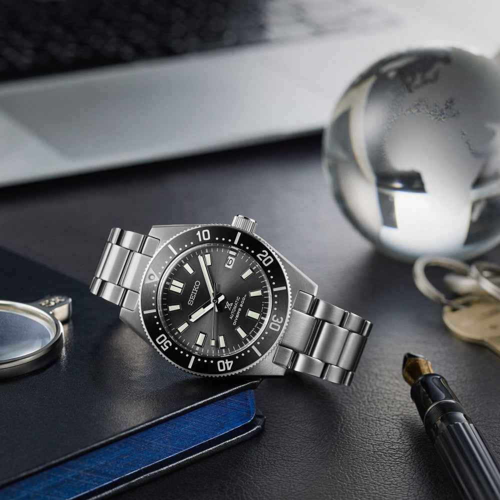 Orologio subacqueo acciaio con quadrante nero e lunetta unidirezionale, bracciale metallico.