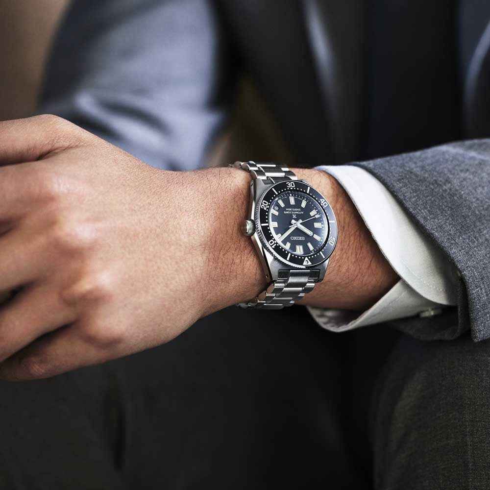 Orologio subacqueo Seiko in acciaio con quadrante nero al polso, cinturino a maglie