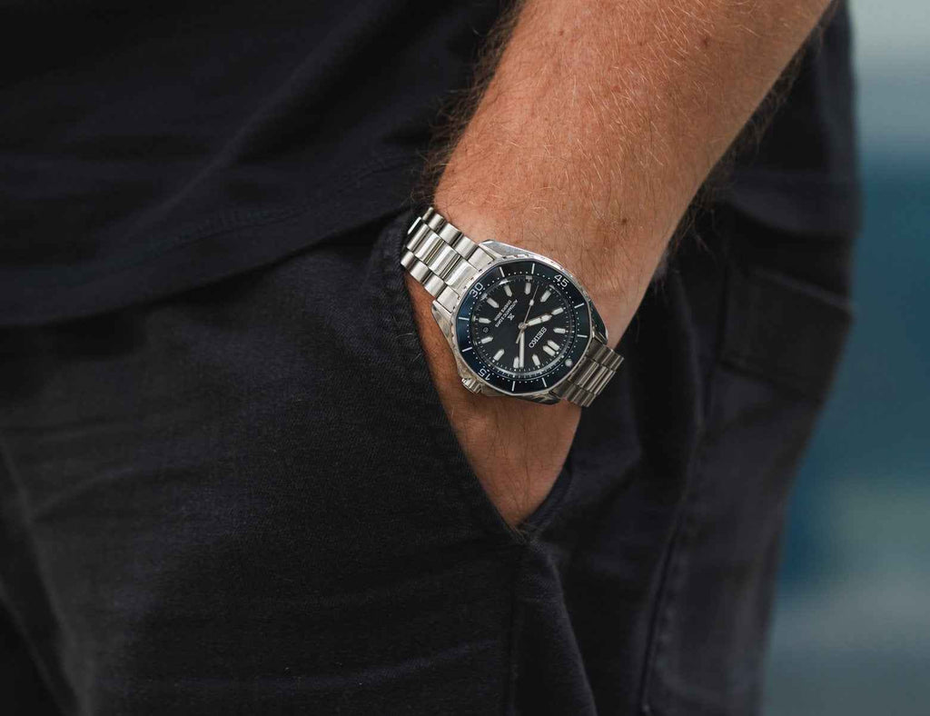 Orologio subacqueo Seiko sul polso, quadrante blu e bracciale in acciaio a maglie.