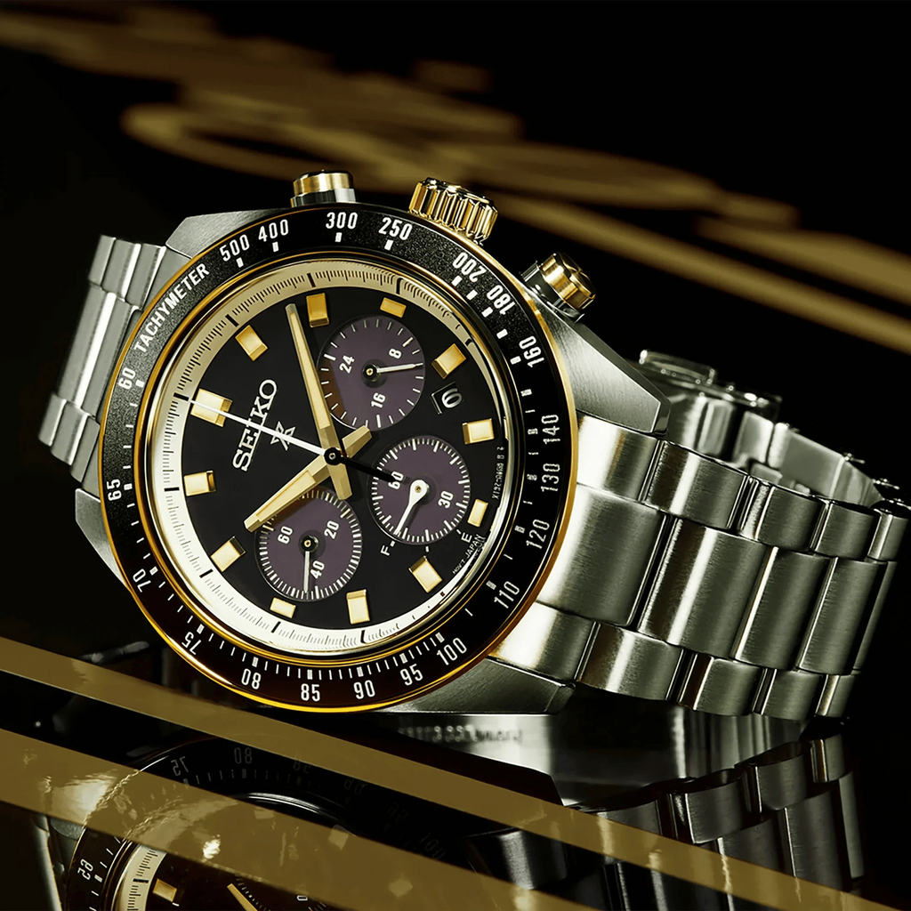 Orologio cronografo nero con ghiera dorata e cinturino in acciaio