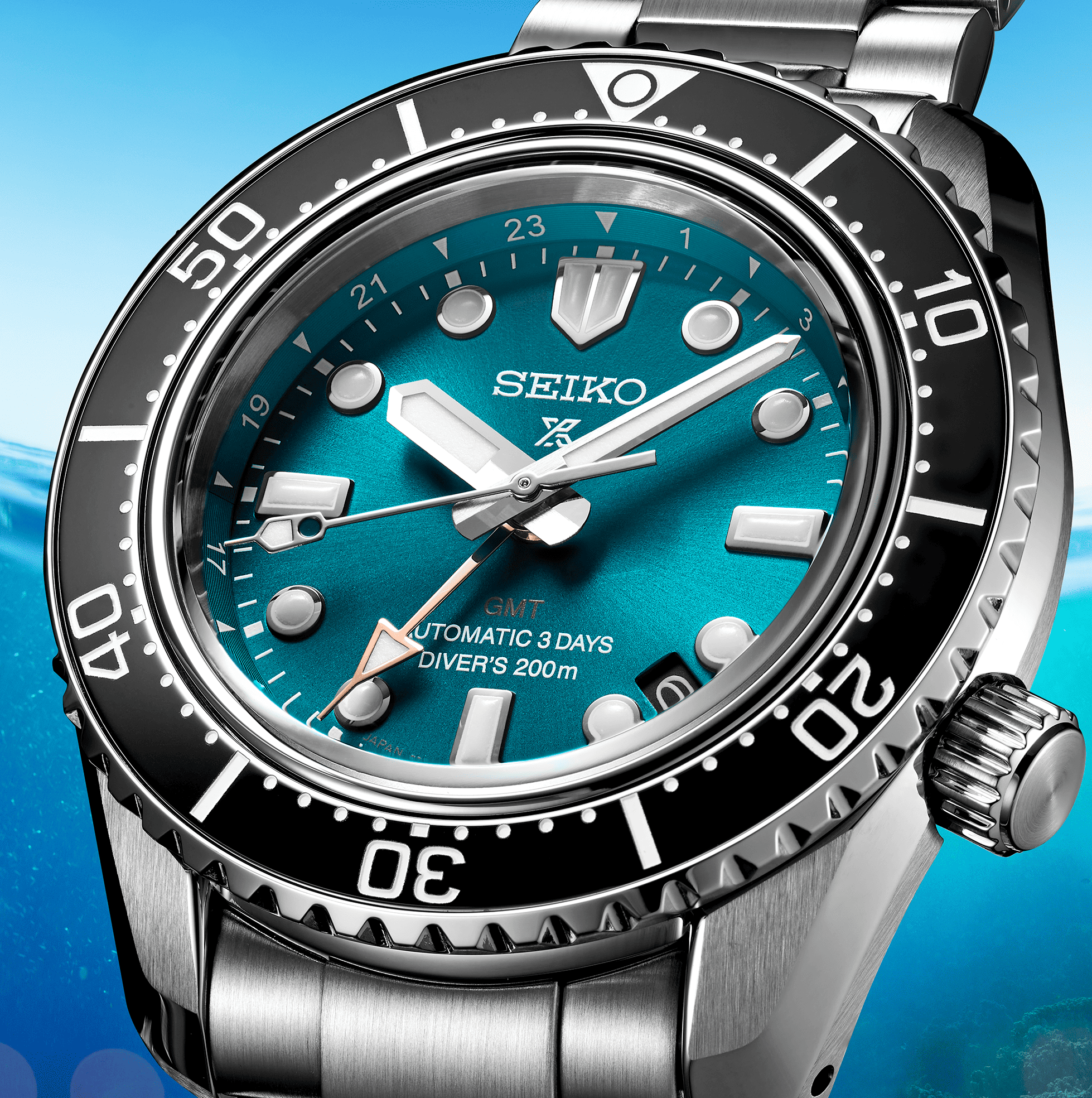 Orologio diver GMT: quadrante blu-verde, lancette e indici luminosi, lunetta nera.
