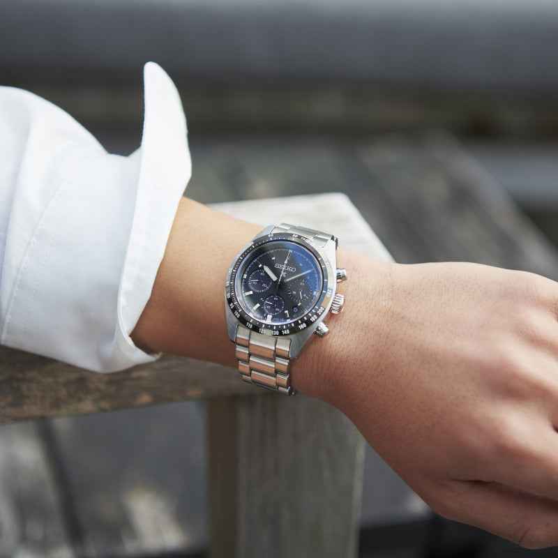 Orologio cronografo solare con quadrante nero e bracciale in acciaio su polso