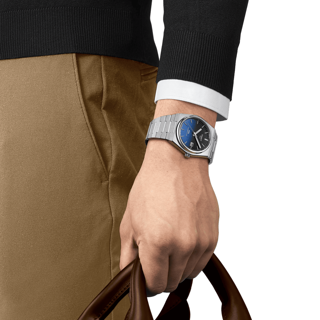 Orologio Tissot su polso con cinturino in acciaio e quadrante blu