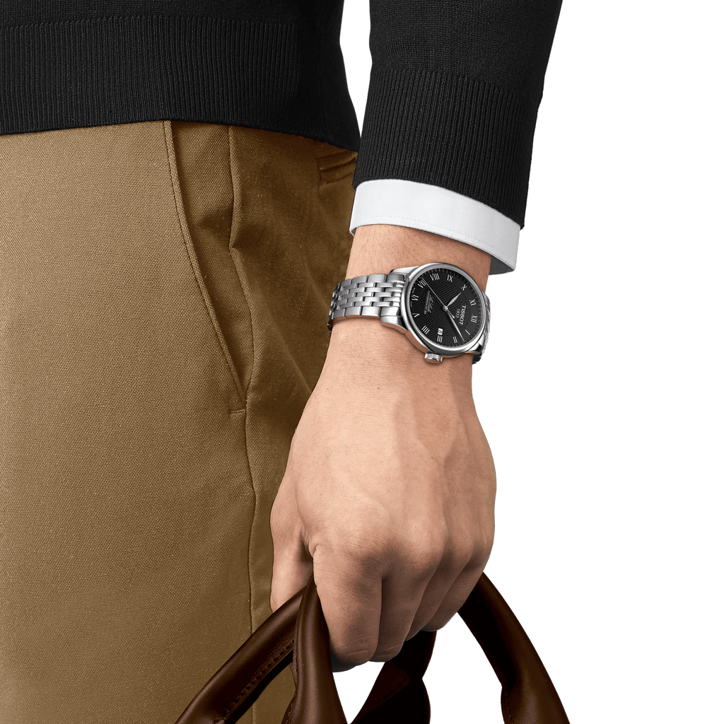 Orologio automatico con cinturino in maglia d’acciaio e quadrante nero, su polso