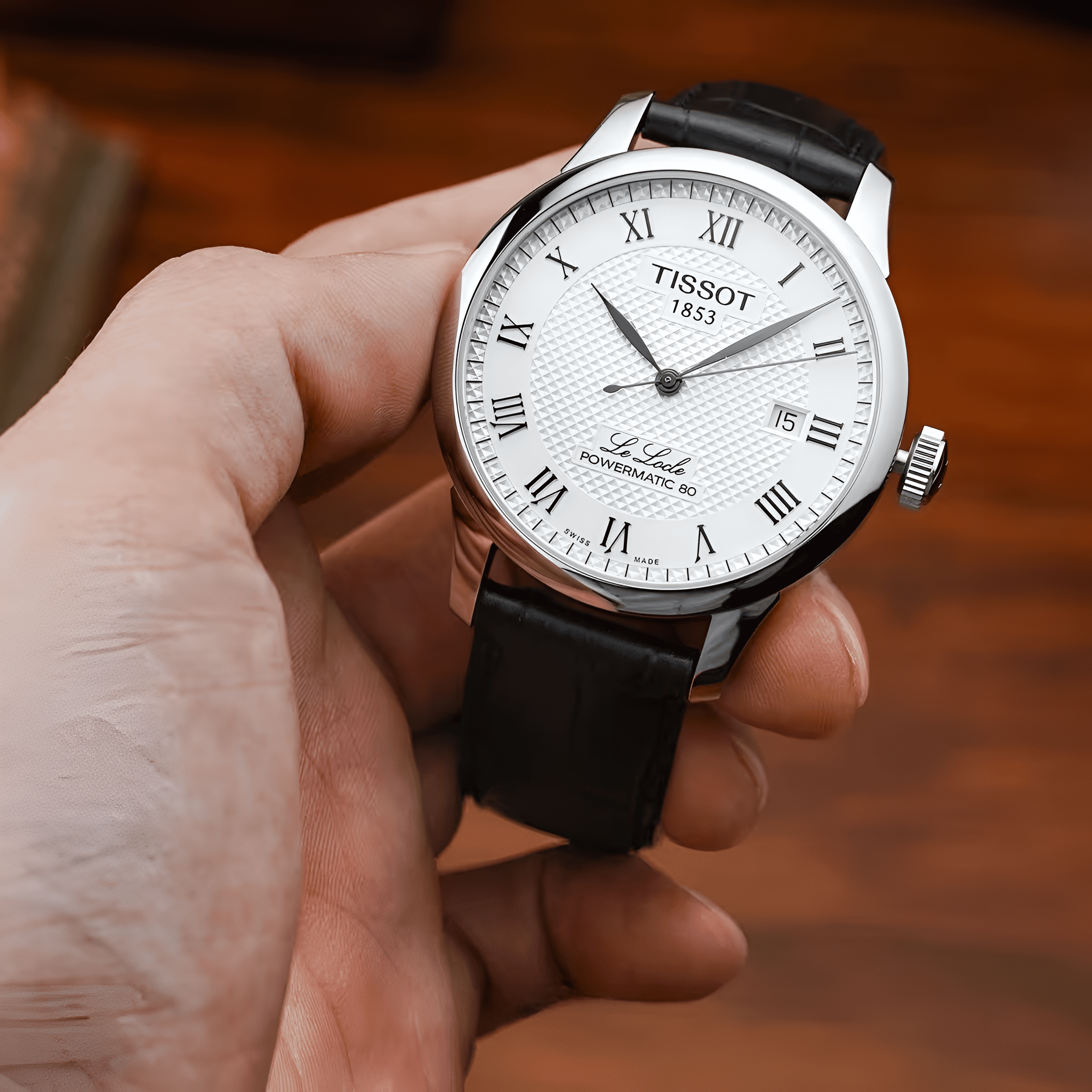 Orologio Tissot con quadrante bianco e cinturino in pelle nera.