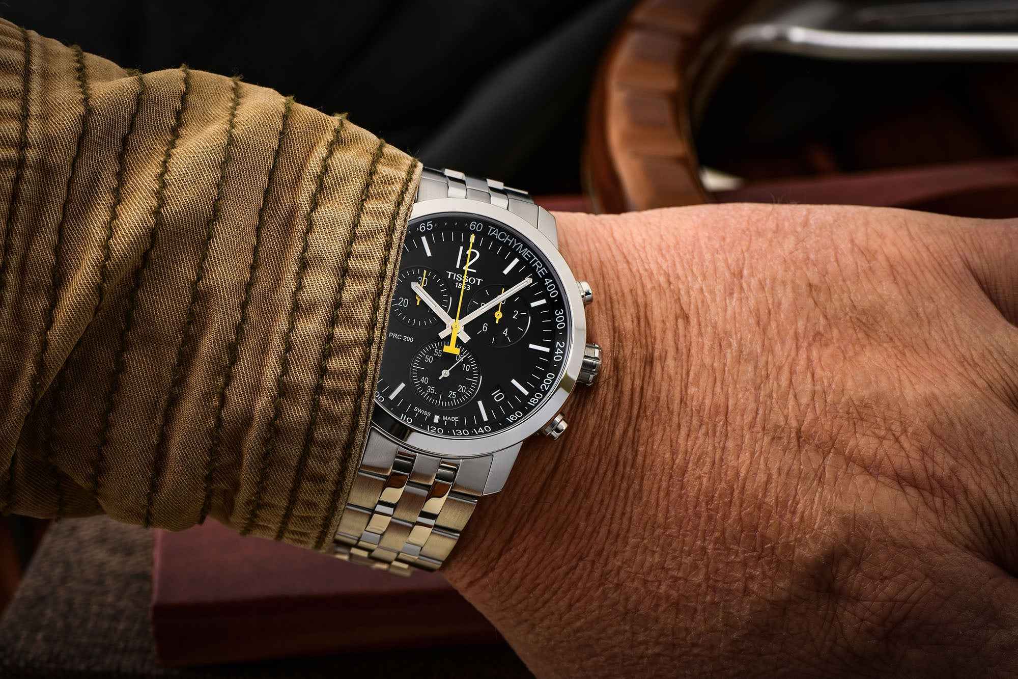 Orologio cronografo con quadrante nero e bracciale in acciaio, indossato al polso
