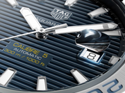 Quadrante blu con datario e scritte TAG Heuer Aquaracer; motivo a linee