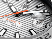 Quadrante dell’orologio con logo TAG Heuer Aquaracer, indici neri e lancette arancioni