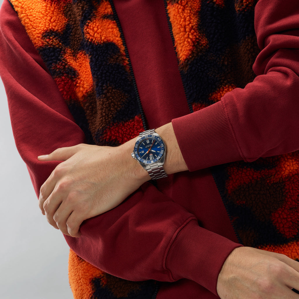Orologio con quadrante blu in acciaio su polso, bracciale a maglie
