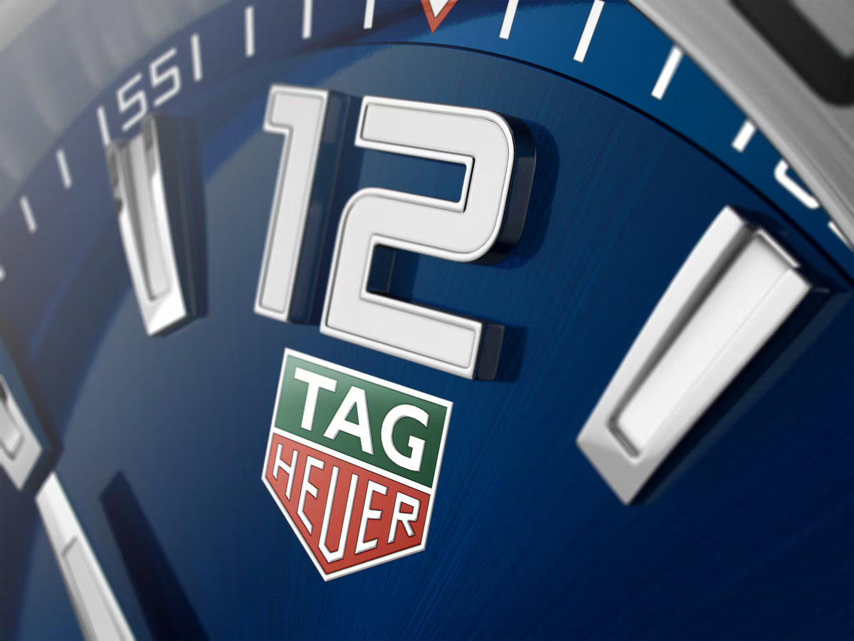 Primo piano quadrante blu con logo TAG Heuer e numeri bianchi luminescenti