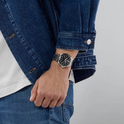 Orologio TAG Heuer su polso con quadrante nero e bracciale in acciaio