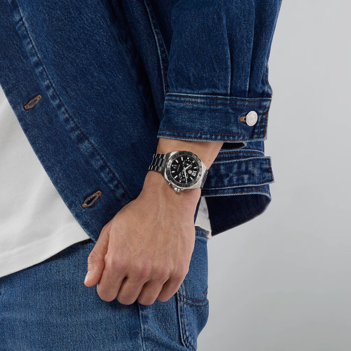 Orologio TAG Heuer su polso con quadrante nero e bracciale in acciaio