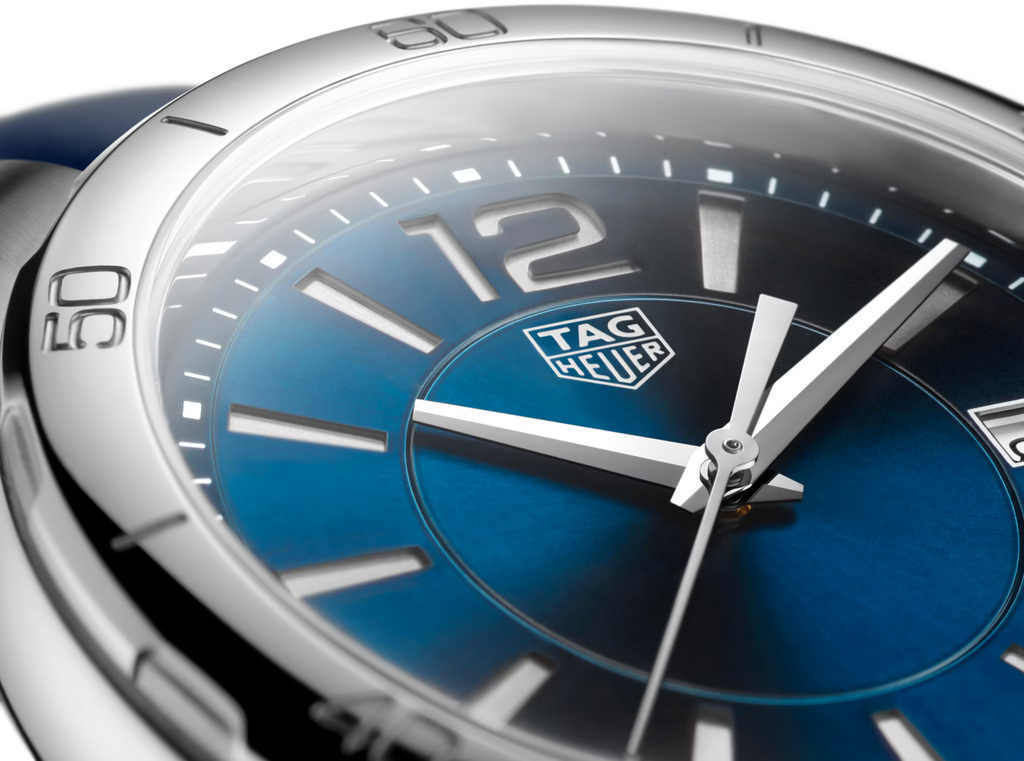 Primo piano orologio TAG Heuer: quadrante blu con lancette bianche e indici numerici.