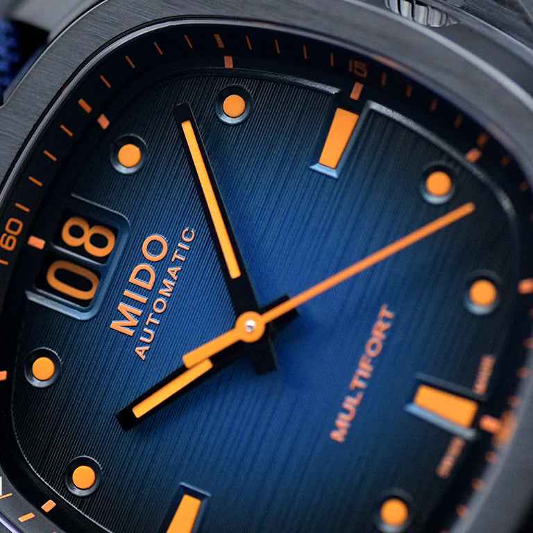 Quadrante blu dell’orologio MIDO con indici arancioni e lancette arancioni