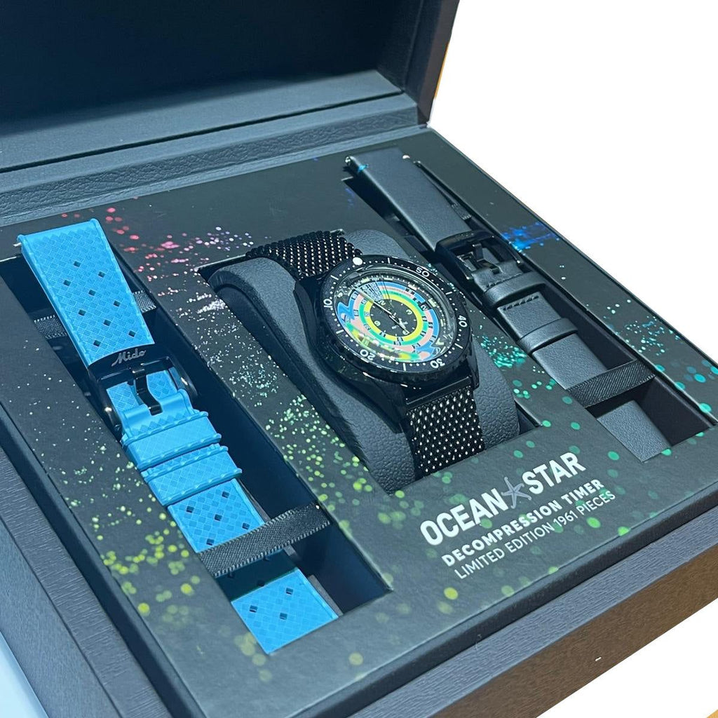 Cofanetto aperto con orologio nero e cinturini azzurri e neri inclusi