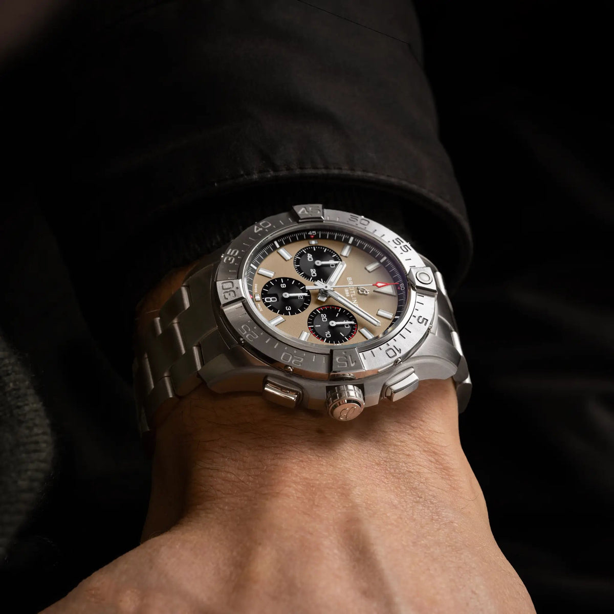 Orologio Breitling Avenger sul polso, quadrante sabbia con cronografi neri e bracciale in acciaio