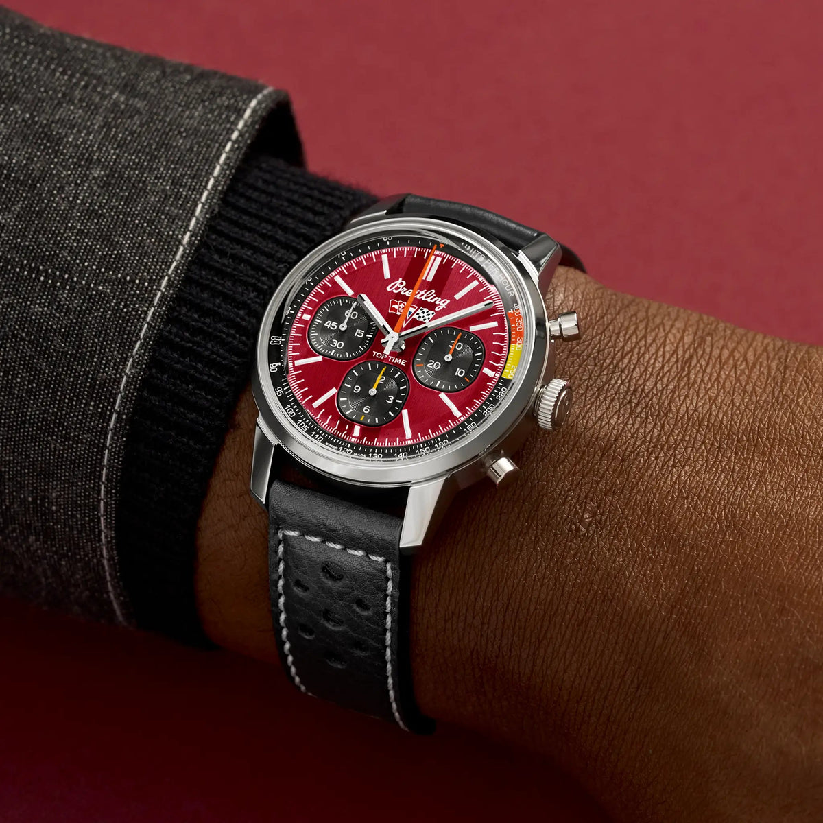 Orologio cronografo su cinturino nero in pelle forata, quadrante rosso