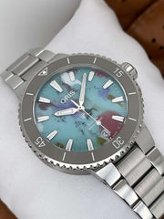 Orologio close-up: quadrante azzurro con tocchi multicolore e bracciale in acciaio