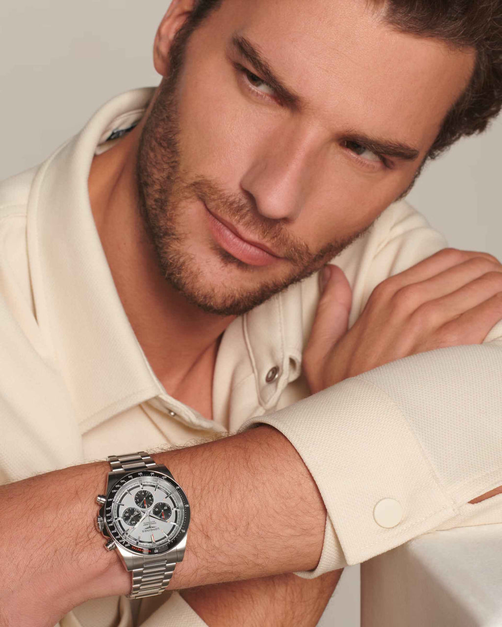 Orologio Longines al polso, cinturino in acciaio argento su camicia chiara