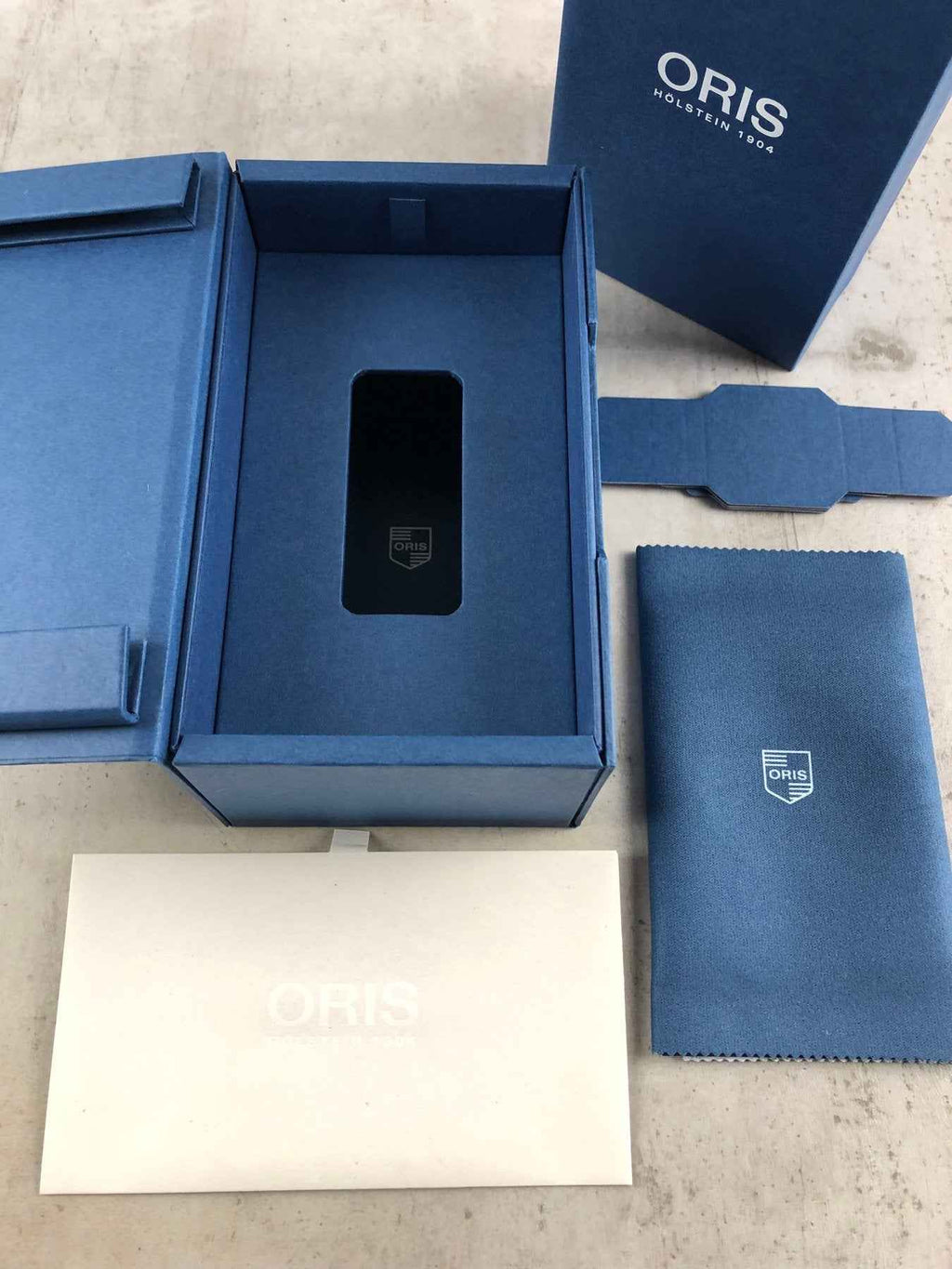 Confezione ORIS con scatola blu, cuscino e astuccio per orologio