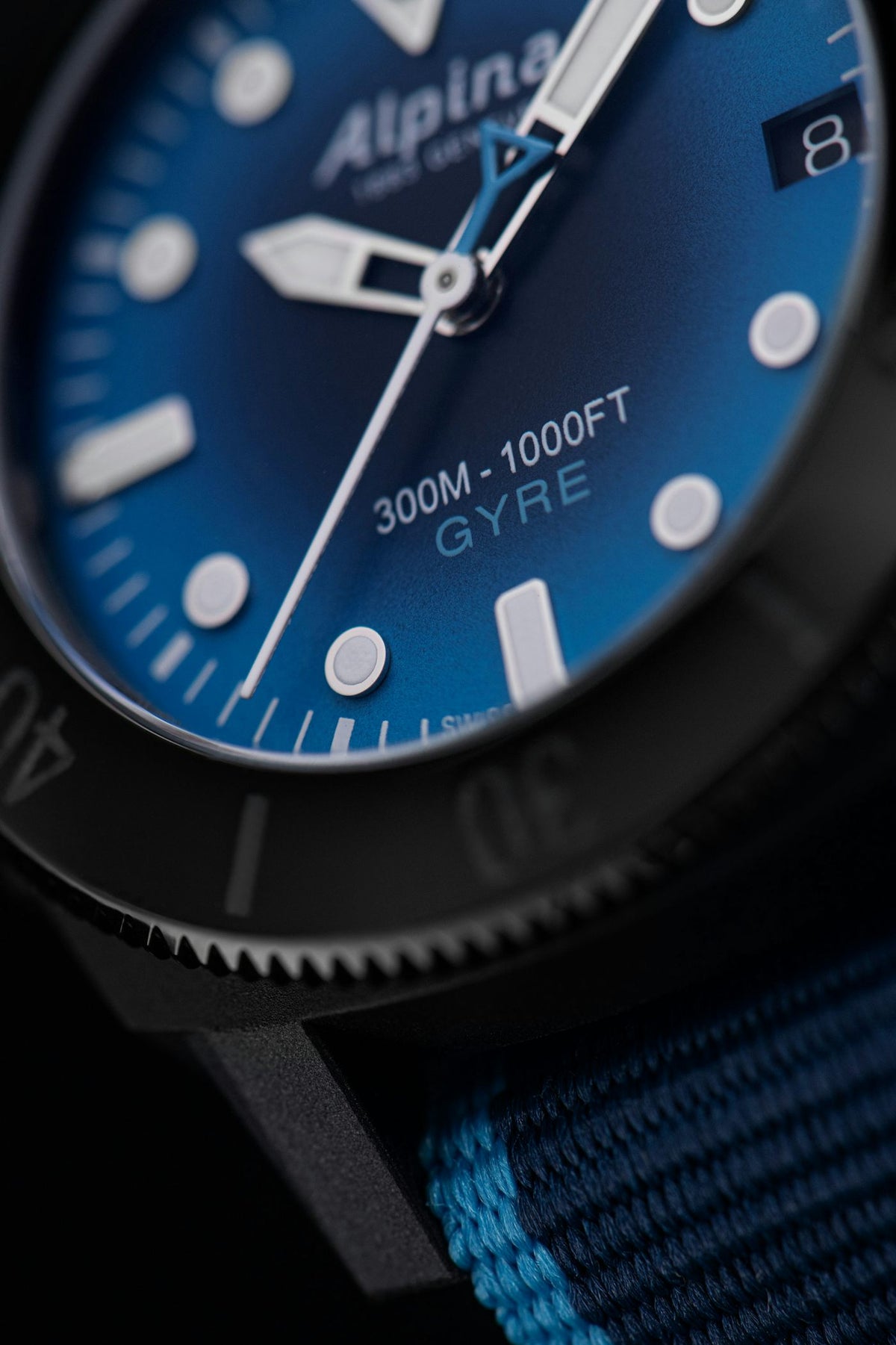 Primo piano quadrante blu con indici, ghiera nera e cinturino NATO blu