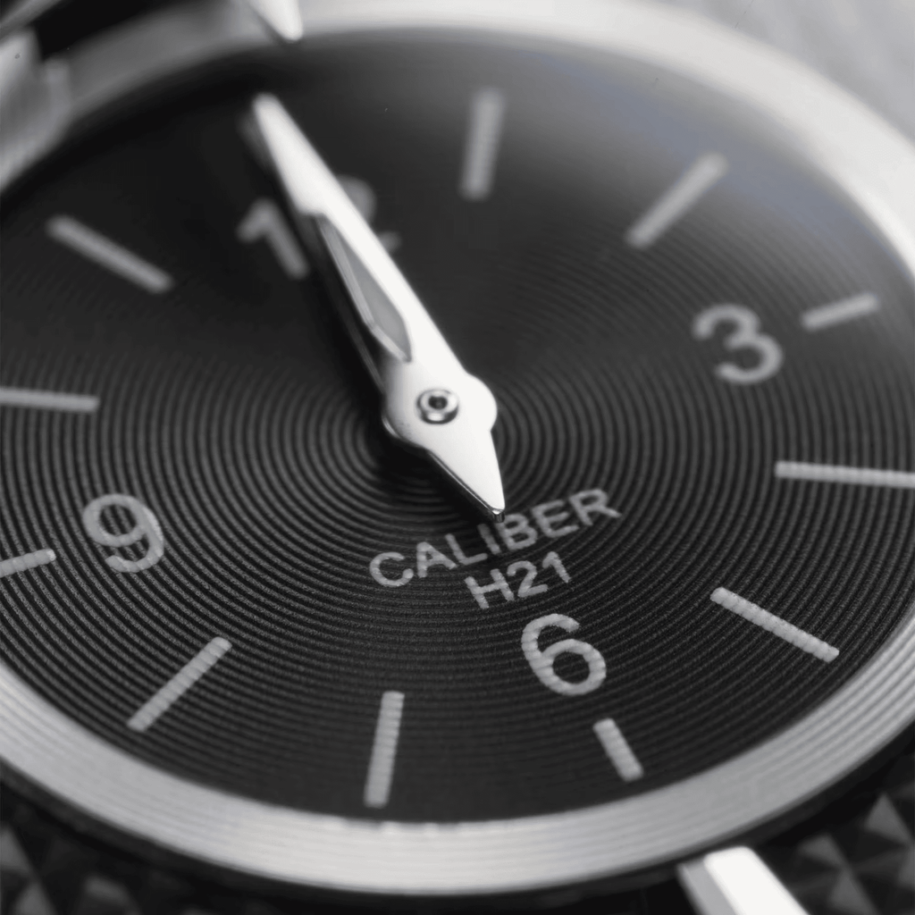 Quadrante nero con lancette bianche e scritta CALIBER H2