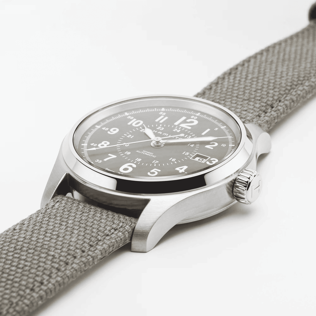 Orologio automatico con quadrante nero e cassa d’acciaio, cinturino canvas grigio.
