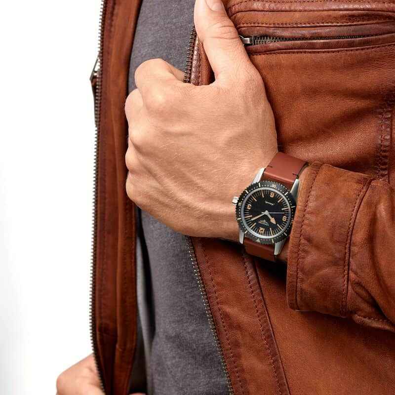 Orologio subacqueo con cinturino marrone in pelle e lunetta nera su polso