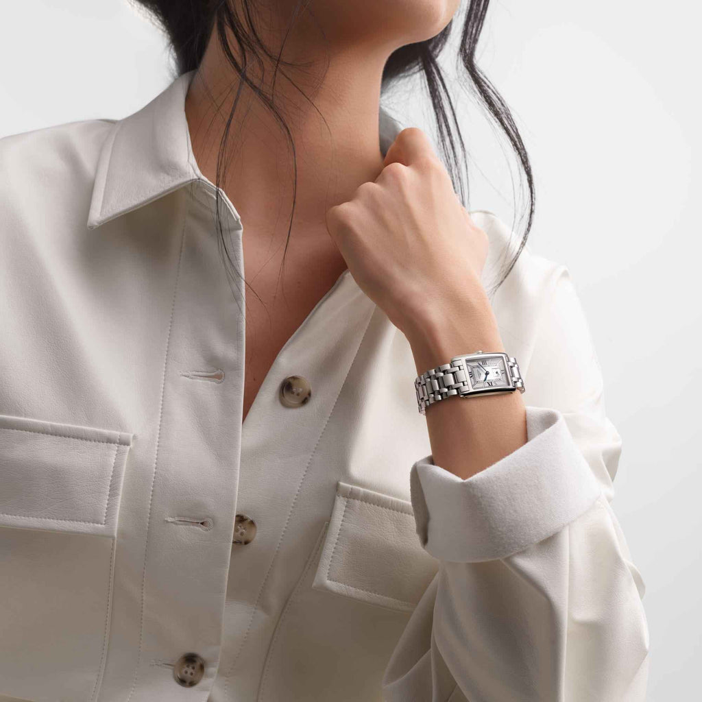 Orologio da polso in acciaio sul polso, indossato con camicia bianca