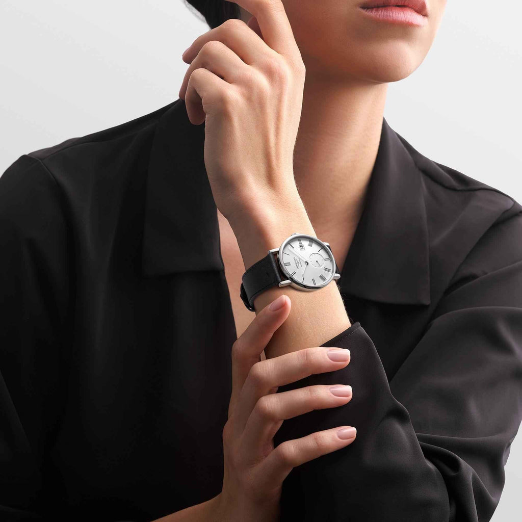 Orologio da polso con quadrante bianco e cinturino nero, indossato al polso