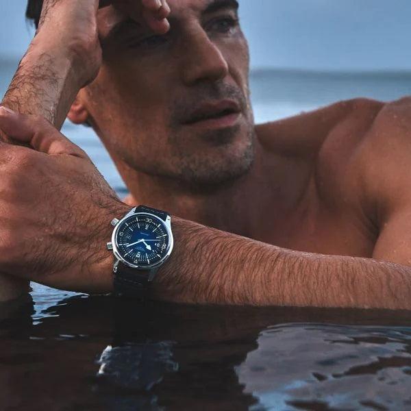 Orologio subacqueo blu con cinturino scuro al polso, quadrante scuro e lancette