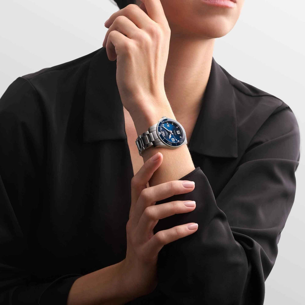 Orologio con quadrante blu e cinturino d’acciaio, indossato al polso