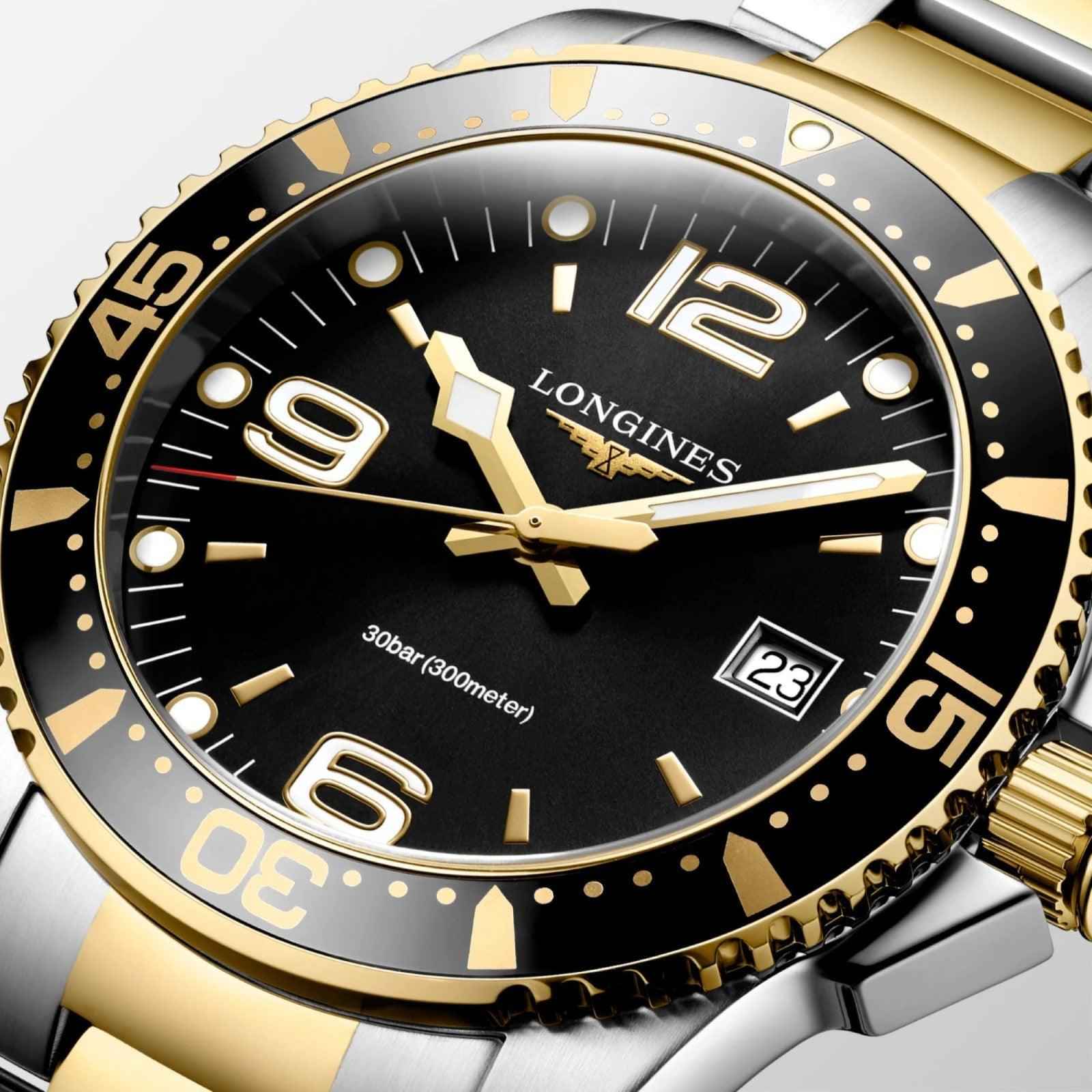 Orologio con quadrante nero, indici dorati e datario, lunetta bicolore oro/acciaio.