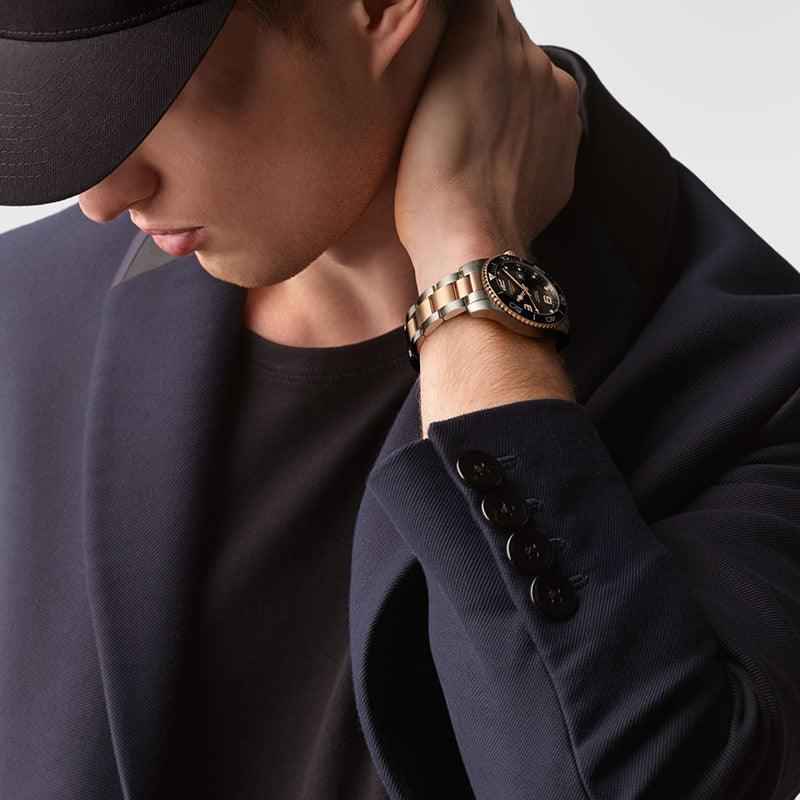 Orologio al polso con cinturino in acciaio bicolore e quadrante nero, dettagli rosé
