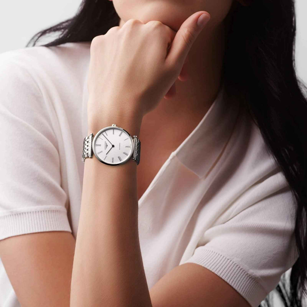 Orologio Longines automatico al polso: quadrante bianco e bracciale maglia acciaio.