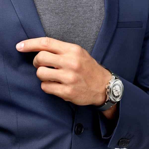 Orologio Longines al polso con cinturino scuro e cassa d’acciaio, indossato con abito blu