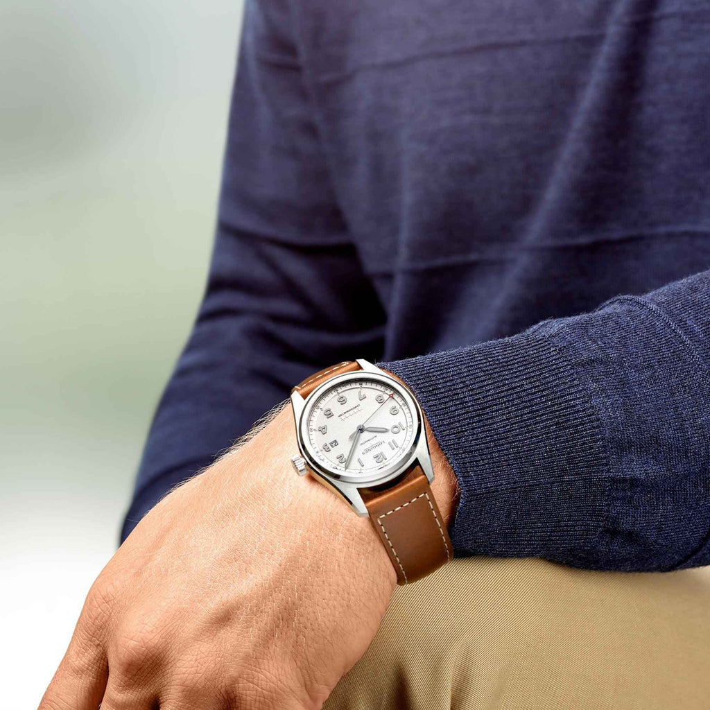Orologio automatico Longines con cinturino pelle marrone al polso, quadrante bianco