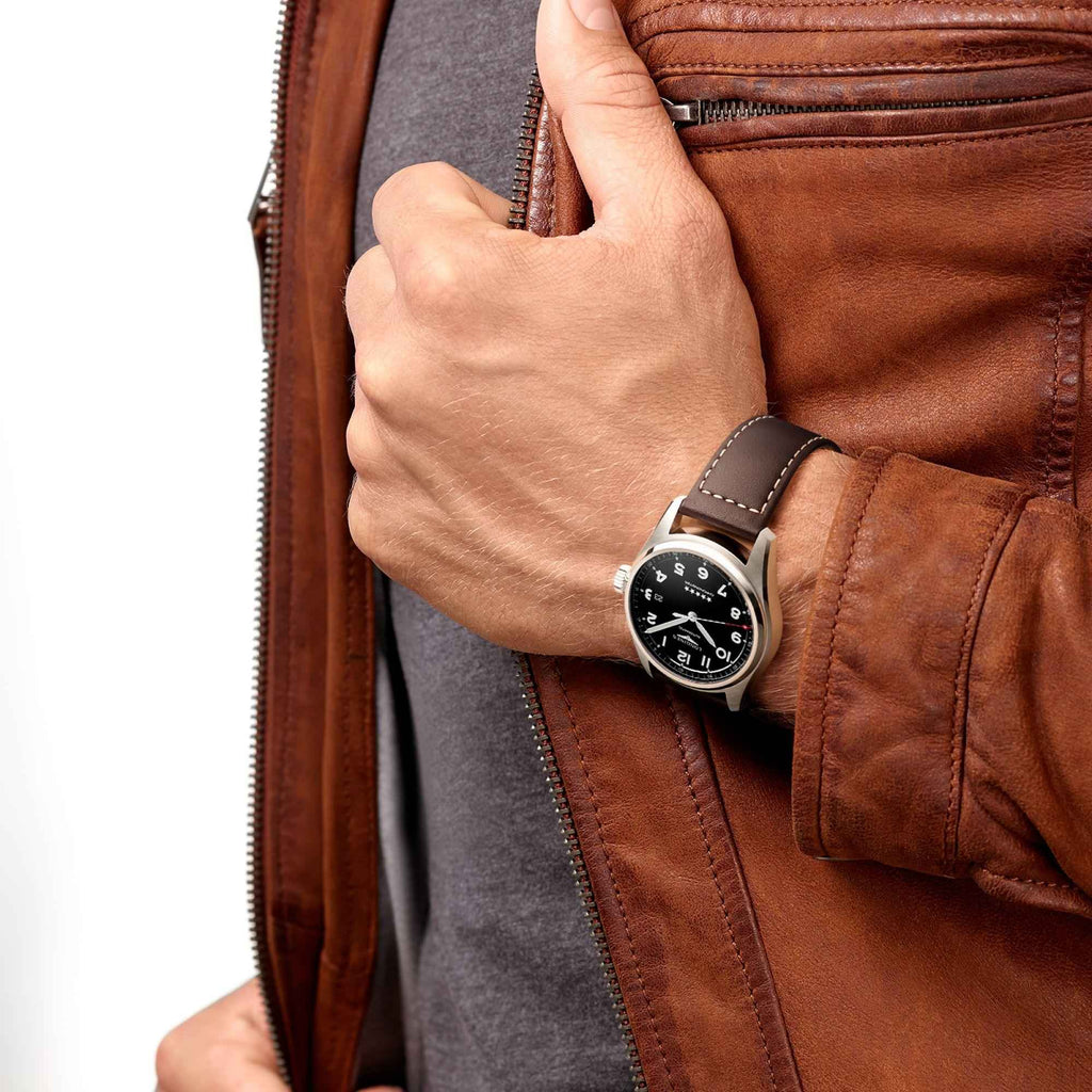Orologio al polso con quadrante nero, cassa in acciaio e cinturino in pelle marrone