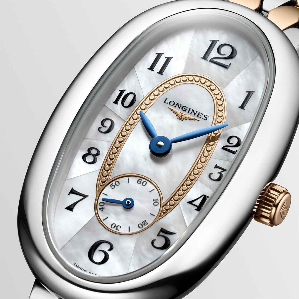 Quadrante madreperla argento con indici neri, numeri arabi e lancette blu