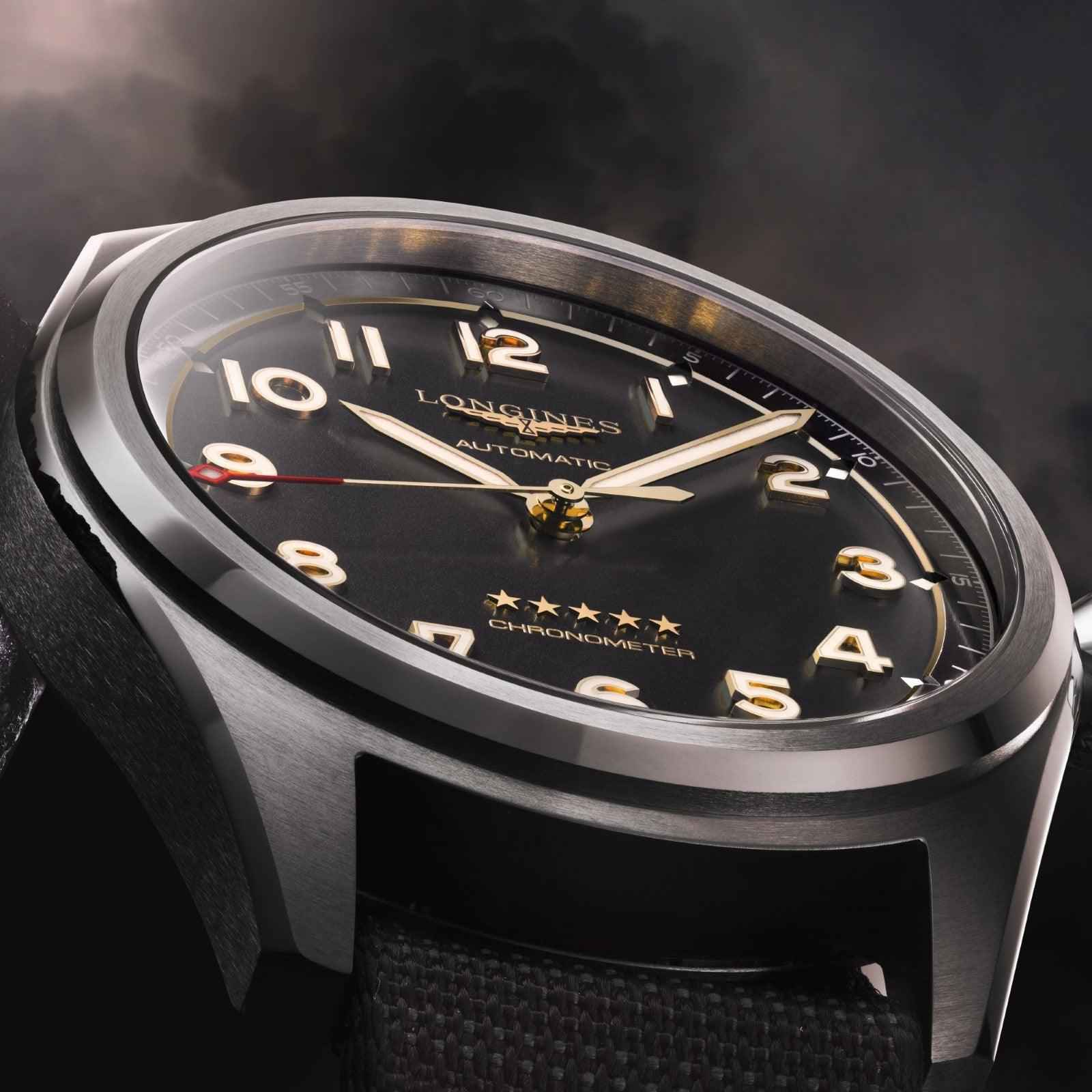 Orologio in cassa metallica con quadrante nero, lancette dorate e cinturino nero