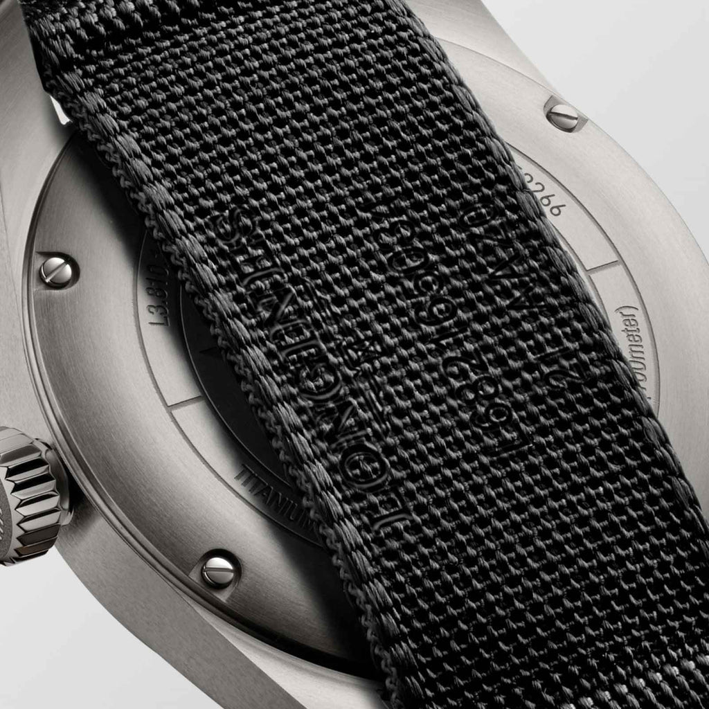 Orologio: lato cassa metallica con incisioni e cinturino in tessuto nero