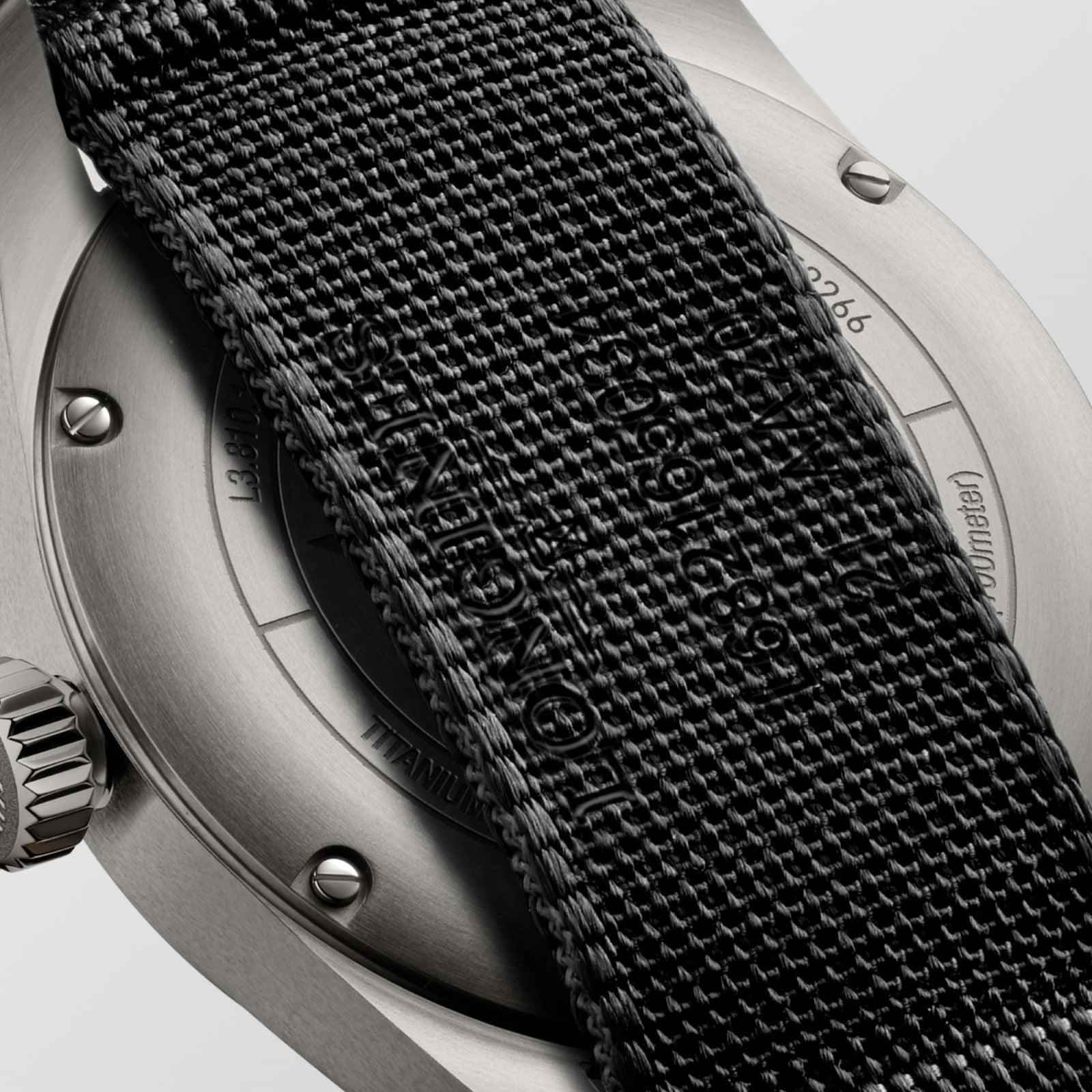 Orologio: lato cassa metallica con incisioni e cinturino in tessuto nero