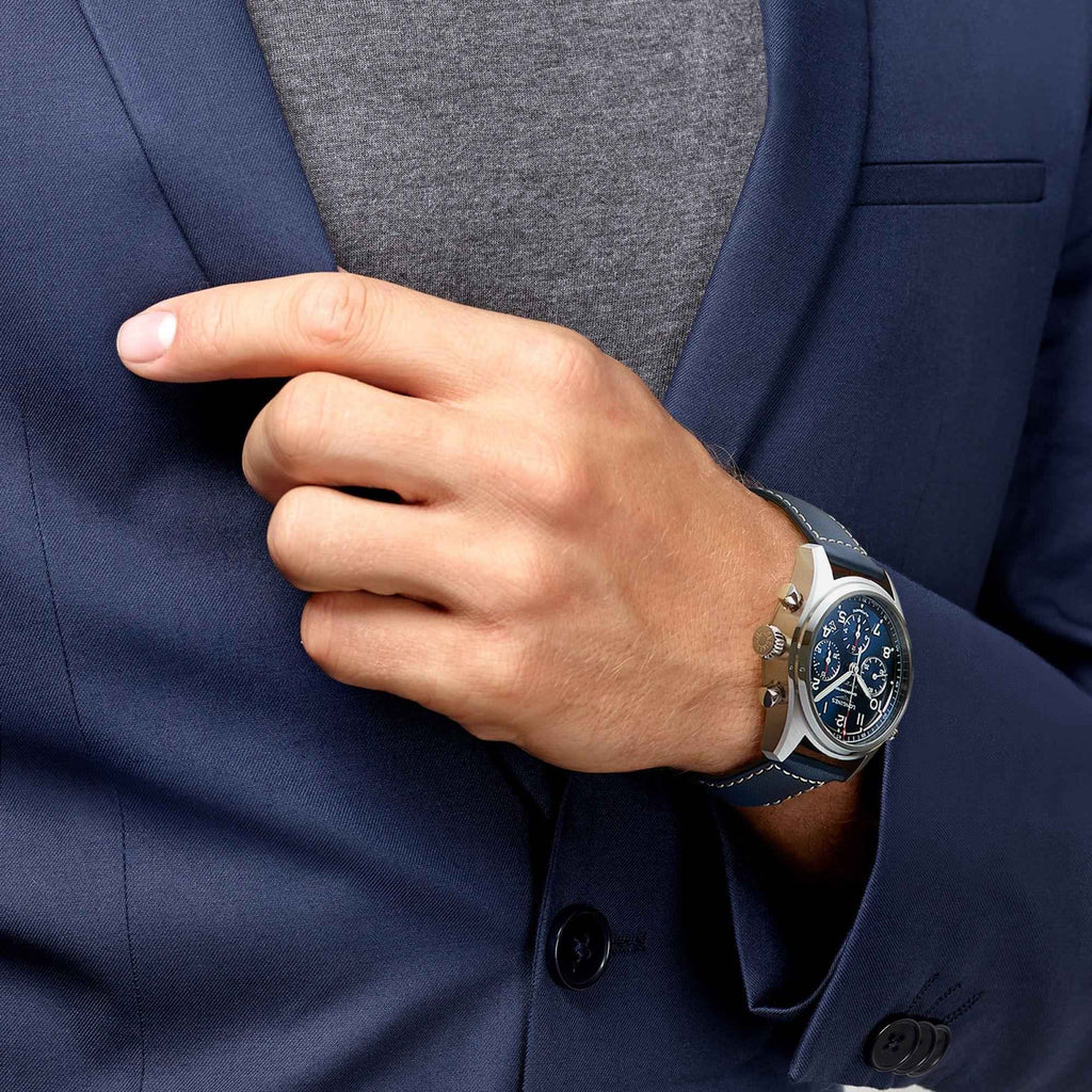 Orologio Longines cronografo al polso con cinturino blu in pelle e quadrante scuro.