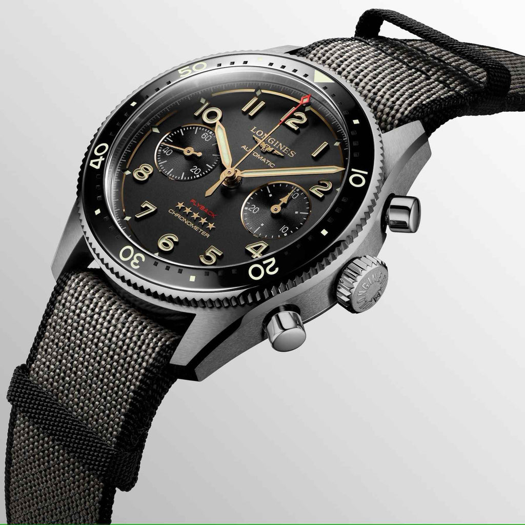 Orologio Longines Spirit Flyback in titanio con quadrante nero e cinturino tessile a maglia.