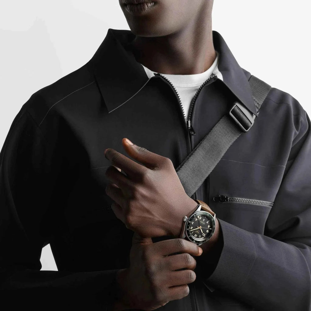 Orologio Longines Spirit Zulu Time al polso con quadrante scuro e cinturino in pelle marrone