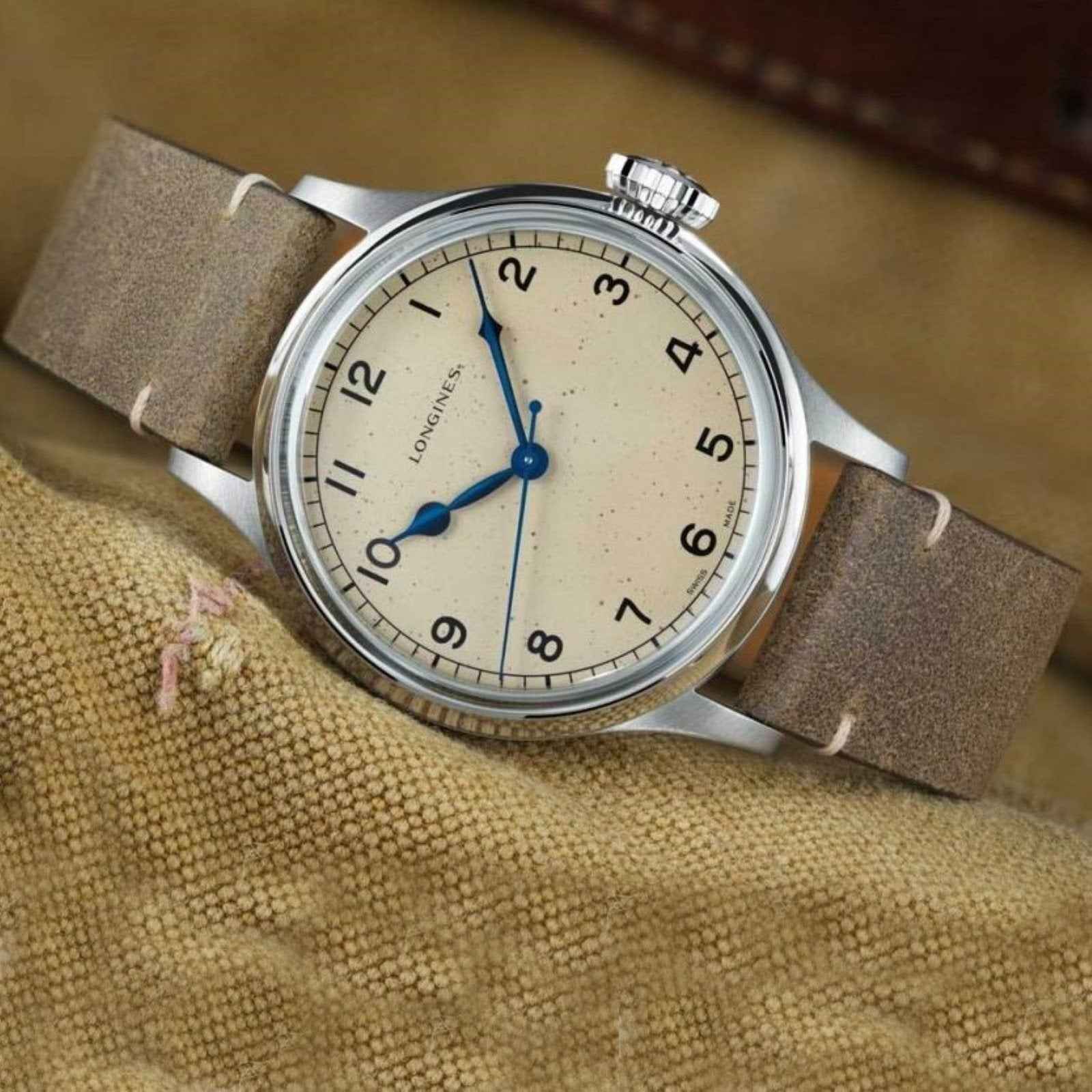 Orologio Longines con quadrante crema e cinturino in pelle marrone, vista laterale