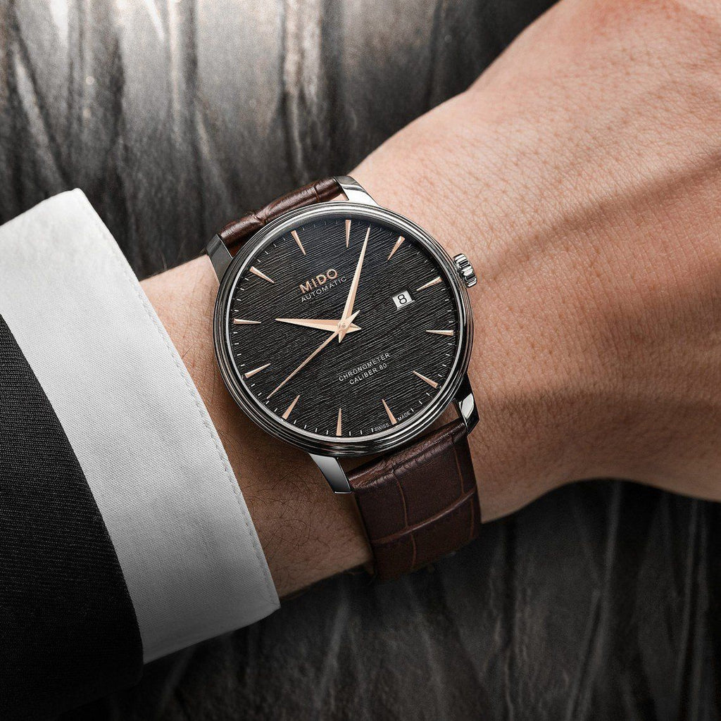 Orologio automatico con quadrante nero e cinturino in pelle marrone, cassa in acciaio.