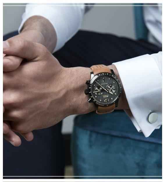 Orologio cronografo al polso con cinturino nero in pelle e quadrante scuro