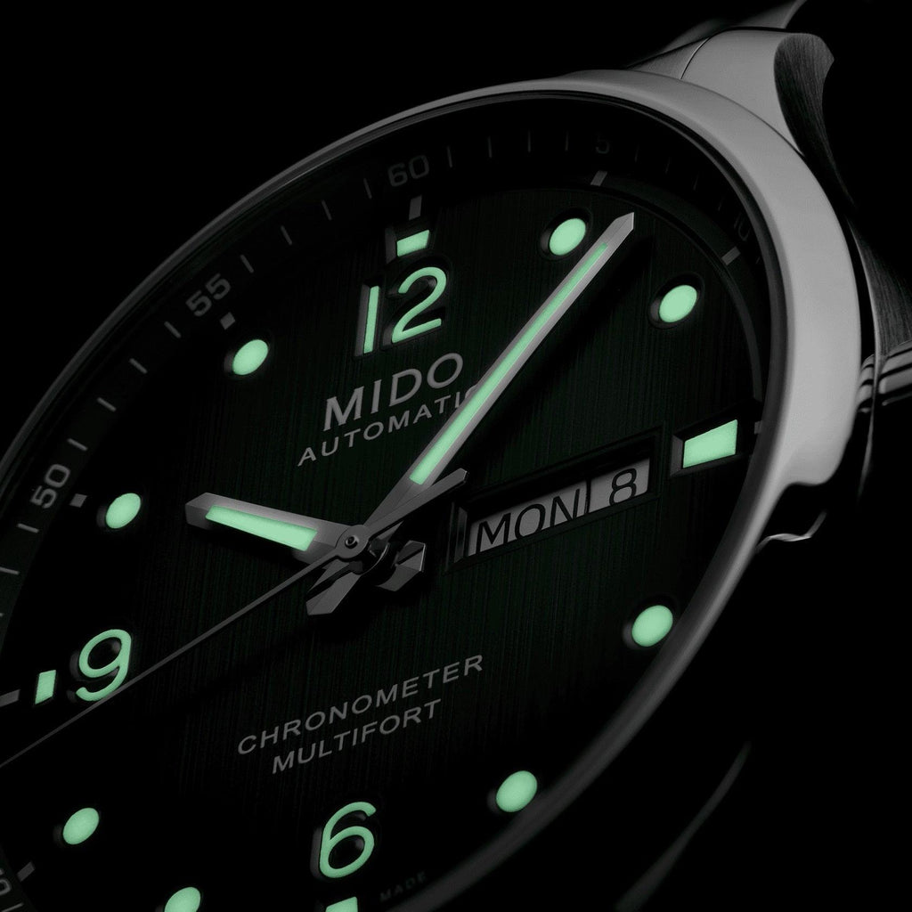 Orologio con quadrante verde scuro, indici luminescenti e data MON 8 visibile